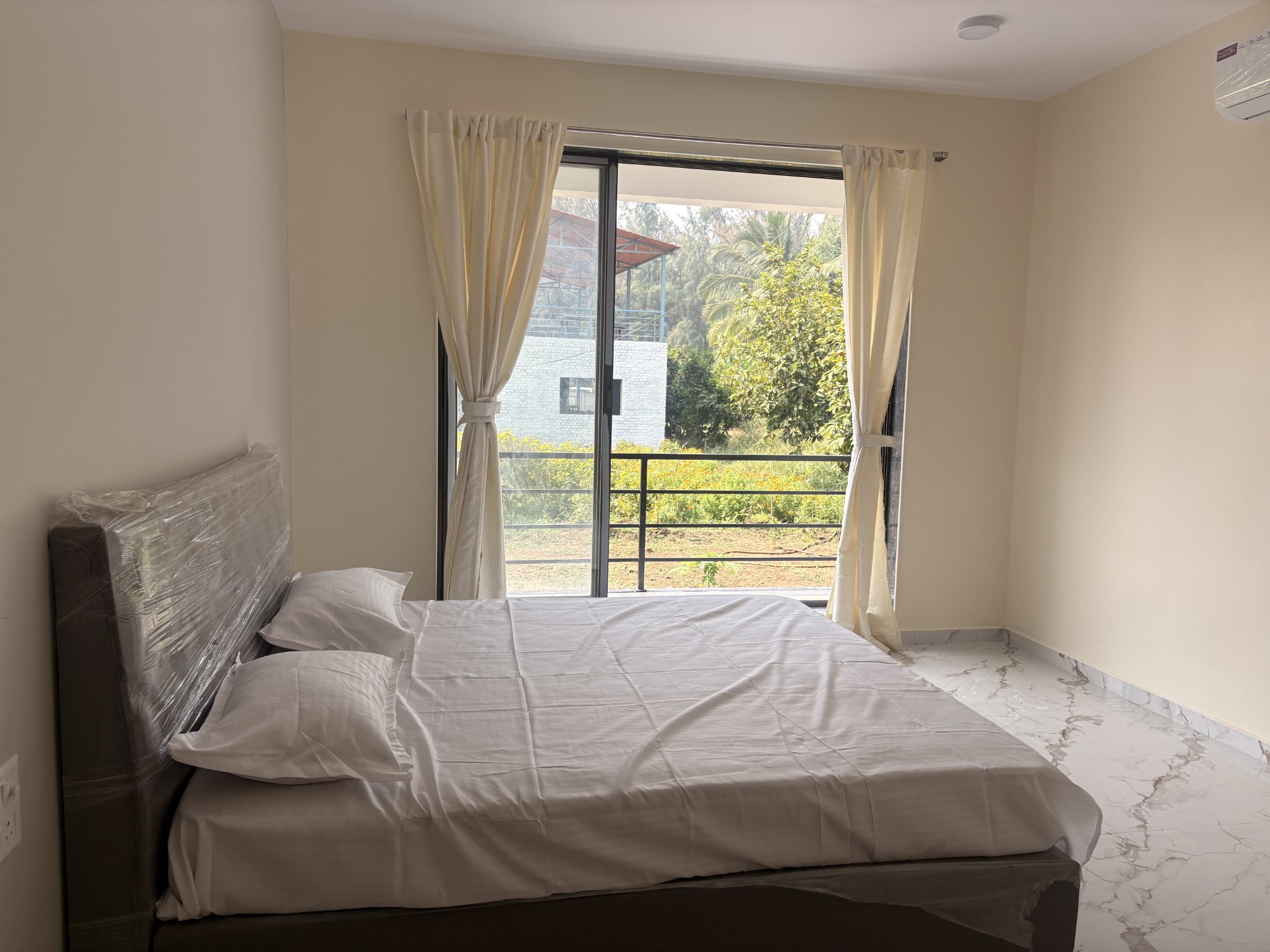 Light-filled guest room with a wide window and balcony access